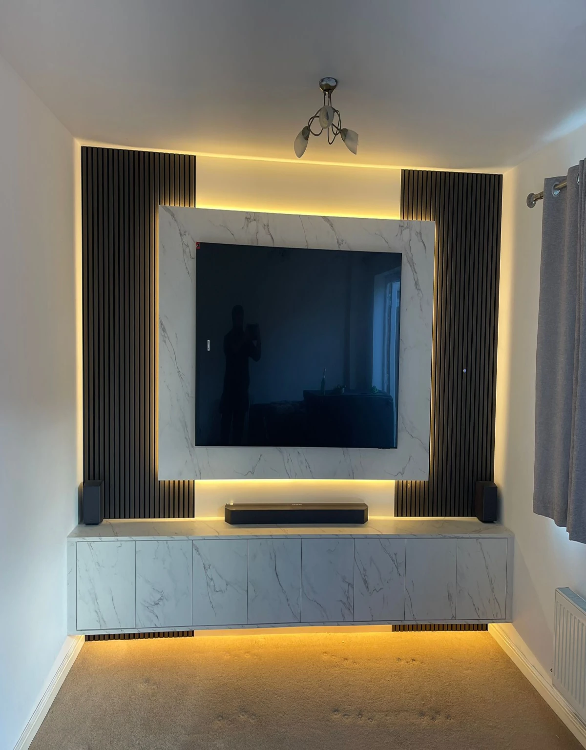 modern-tv-media-wall-marble-panel-led-lighting Modern luxury media wall combining marble-effect finishes, black slatted panels and ambient LED lighting for a stylish contemporary living space