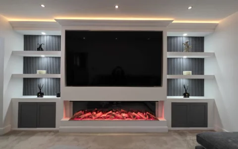 Contemporary living room media wall with electric fire and custom shelving